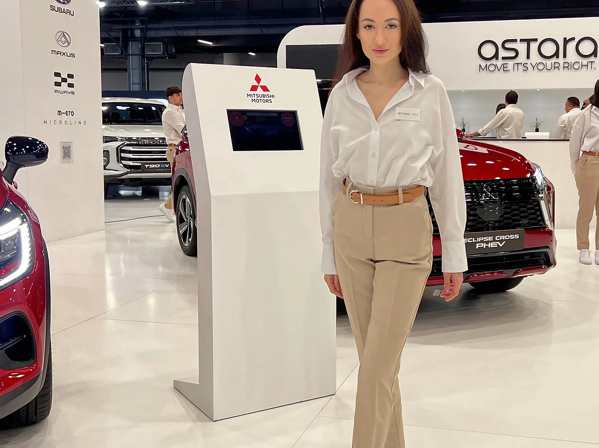 Stylish hostess at a Mitsubishi Motors booth showcasing their latest car models