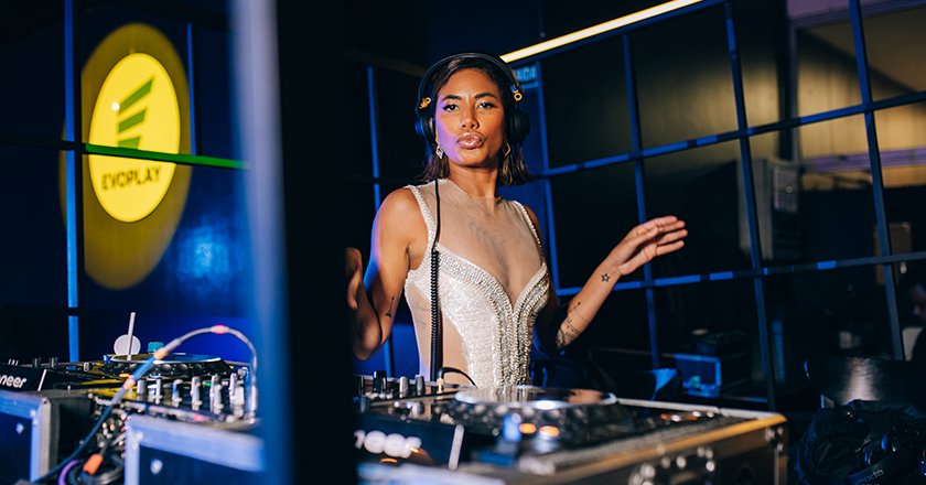 Female DJ performing live at an event with professional equipment