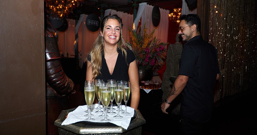Smiling bartender serving champagne at an event